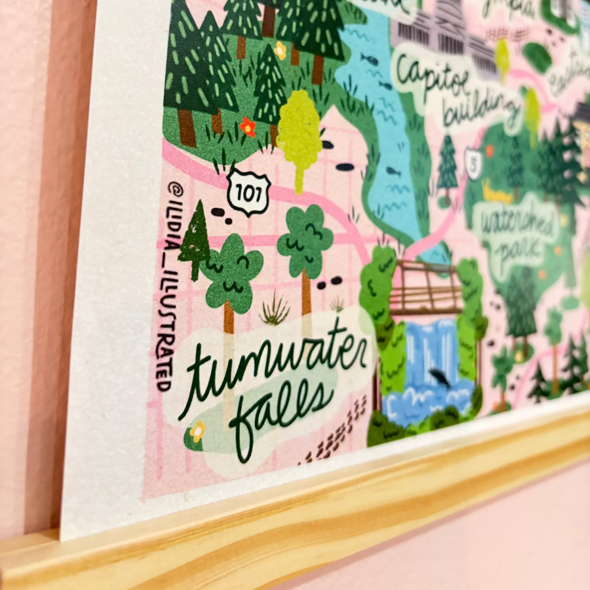 Illustrated map of Tumwater Falls with trees and buildings on a pink background