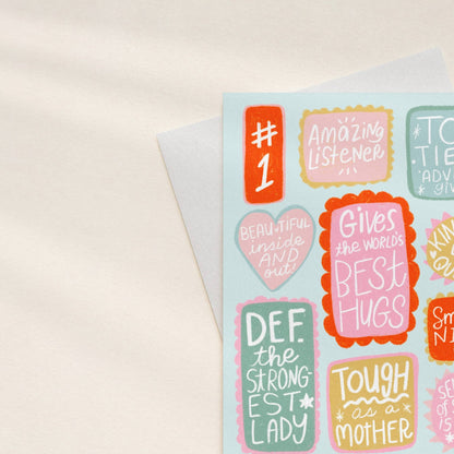 Sheet of colorful stickers with motivational phrases on a light background
