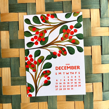 December calendar with a decorative tree design on a woven wooden surface