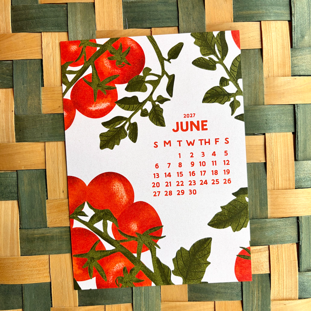 Calendar for June 2026 with tomato design on a woven mat background