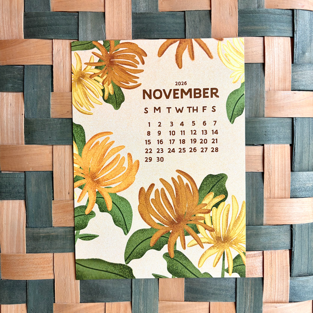 November 2026 calendar with floral design on a woven wooden surface