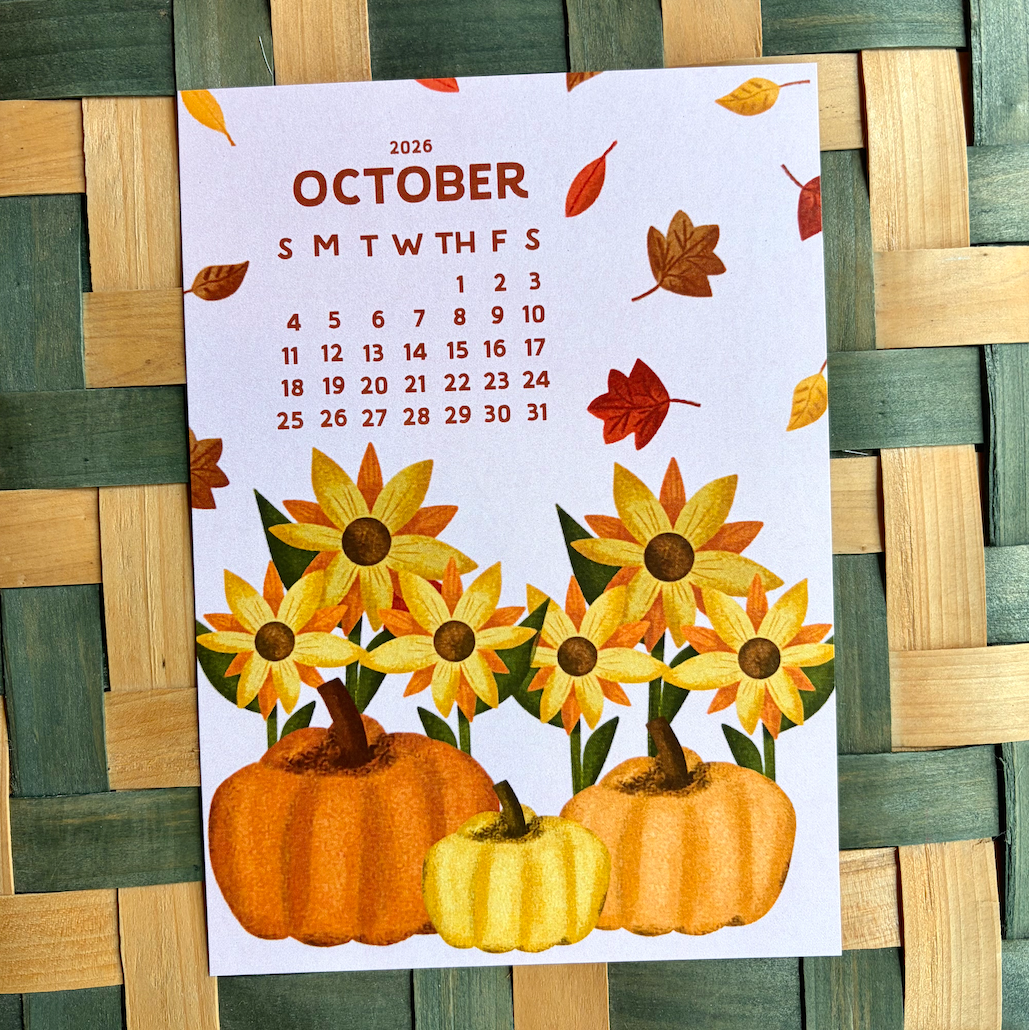 Calendar for October with pumpkins and sunflowers on a woven surface