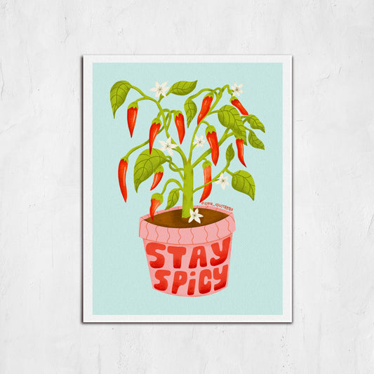 Framed artwork of a potted plant with red peppers and 'Stay Spicy' text on a light blue background.
