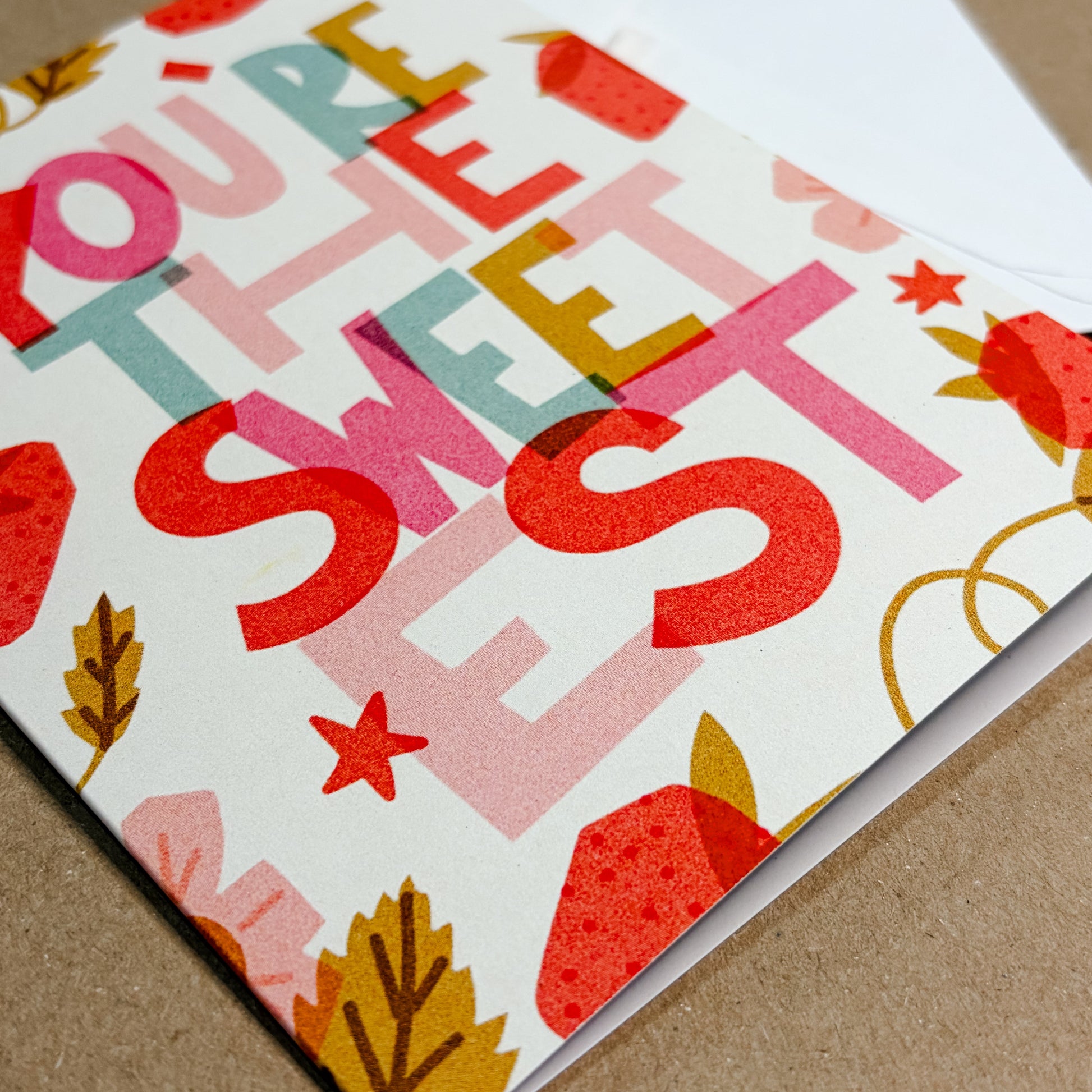 Colorful card with 'You're the sweetest' text on a brown surface