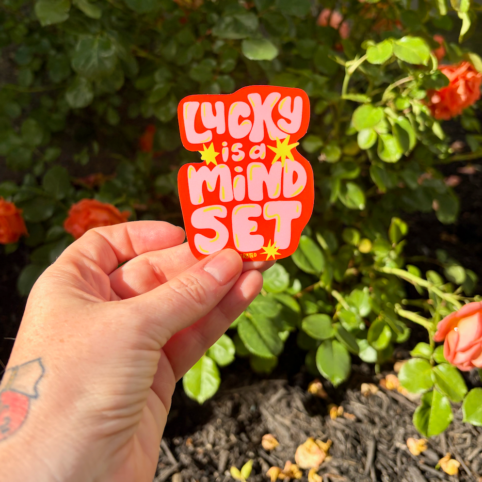 Lucky is a mind set sticker on flower background