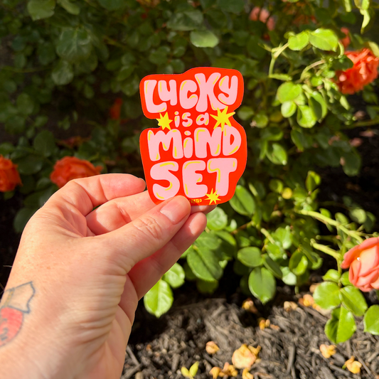 Lucky is a mind set sticker on flower background