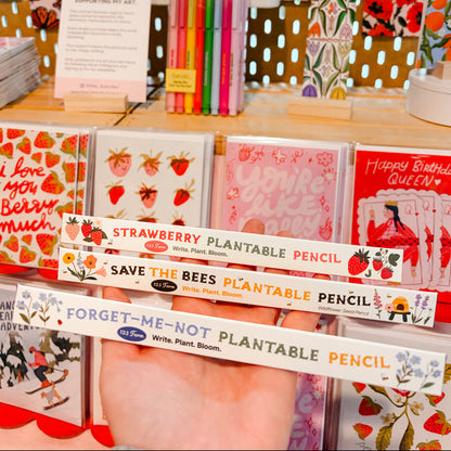 Display of plantable pencils and greeting cards with a decorative background.