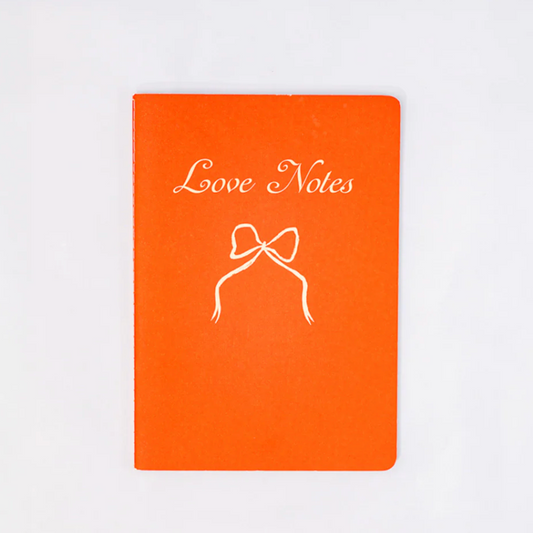 Orange notebook with 'Love Notes' and a bow illustration on a white background