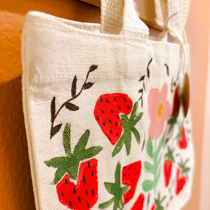 Small pouch with strawberry pattern on a plain background