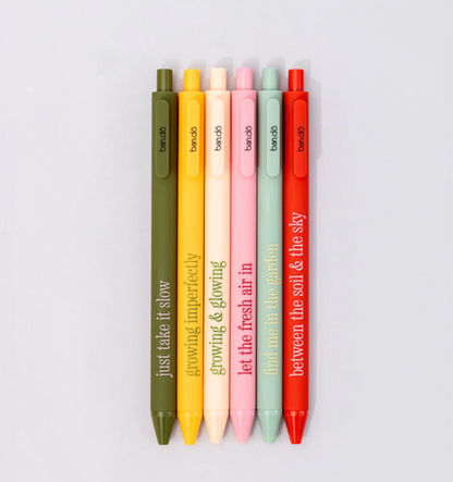 Set of colorful pens with motivational phrases on a light gray background